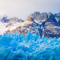 a photo of a glacier in chile and snow covered mountains