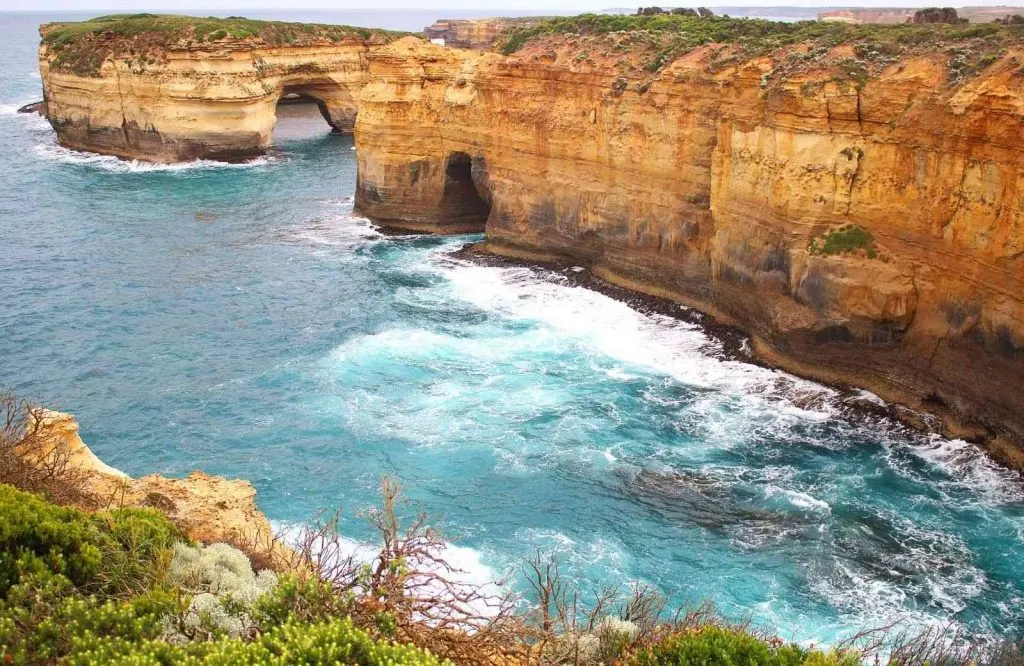 Cliffs in the ocean with arches in them, the natural wonder of Loch Ard Gorge, for your Great Ocean Road stops itinerary.
