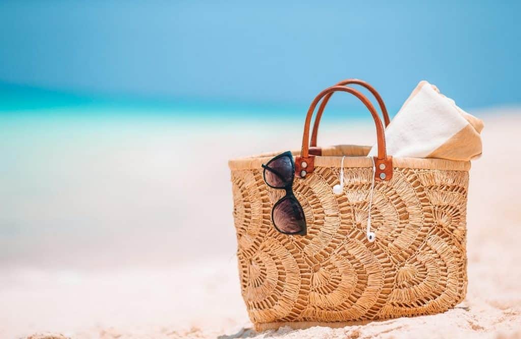 A brown beach bag on the beach which is perfect for your Tulum packing list.