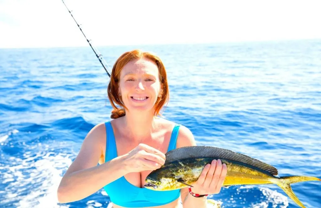 A woman holding a fish she caught on a fishing trip which is one of the best outdoor things to do in Biloxi Mississippi.