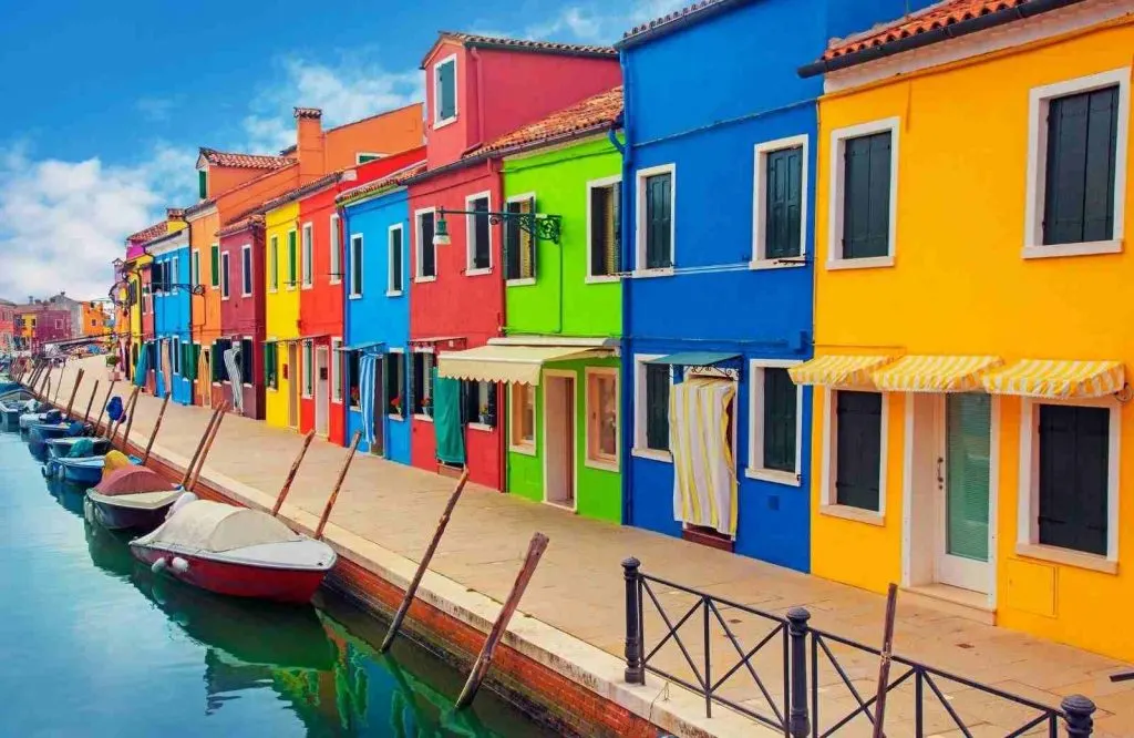Colorful buildings on a canal on the island of Burano, things to know when visiting Venice.