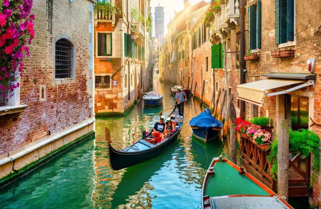 A gondola in the canals of Venice for things to know before traveling to Venice.