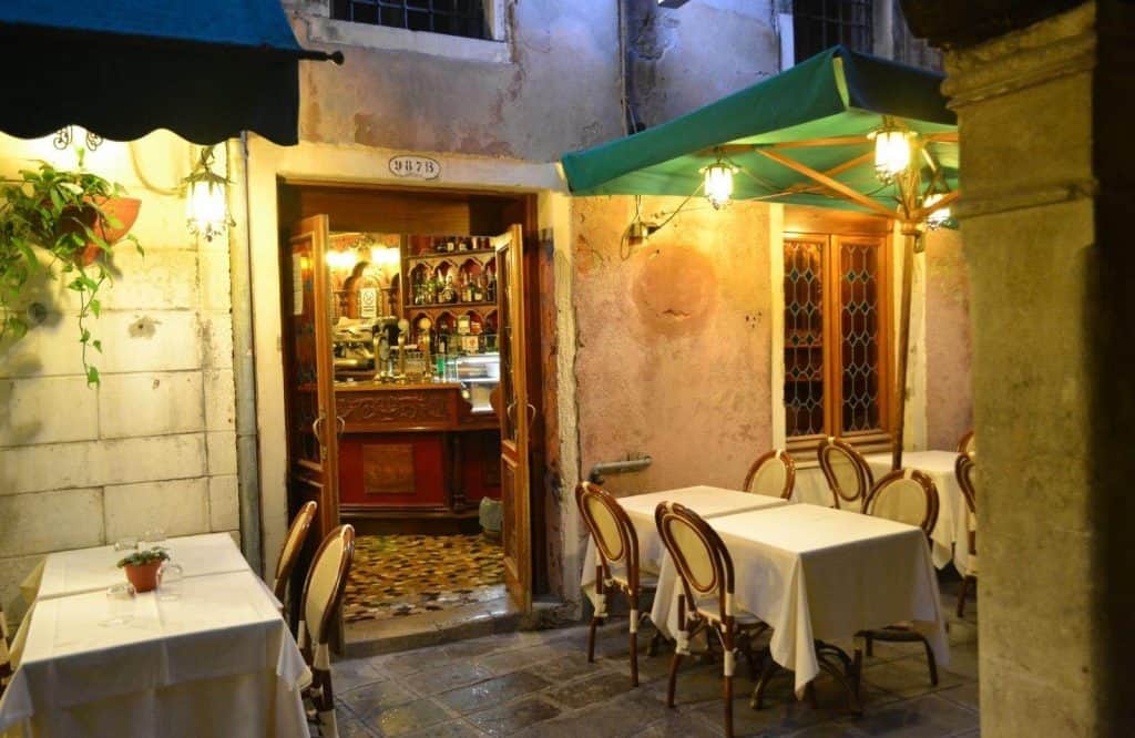 A restaurant in the evening and one of the things to know when visiting Venice is that restaurants will charge a cover charge.