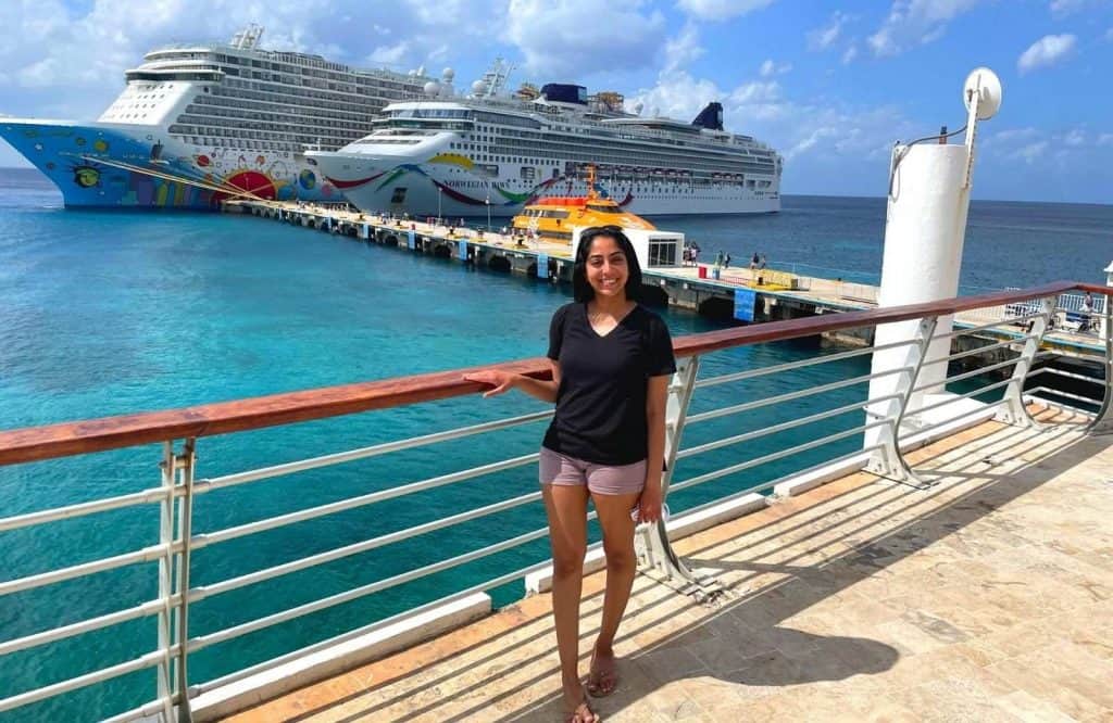 Me standing on the pier in front of two cruise ships for how to get to Playa del Carmen from Cozumel.