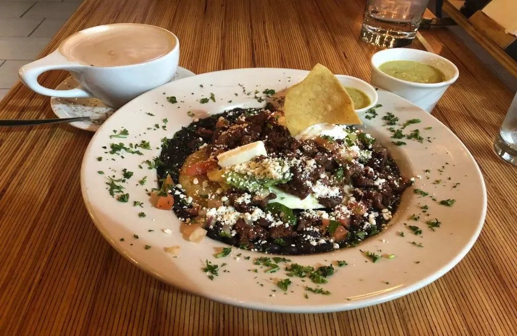 Latte, salsa verde, and a plate of food beautifully garnished at Cafe Kacao for one day in Oklahoma City.