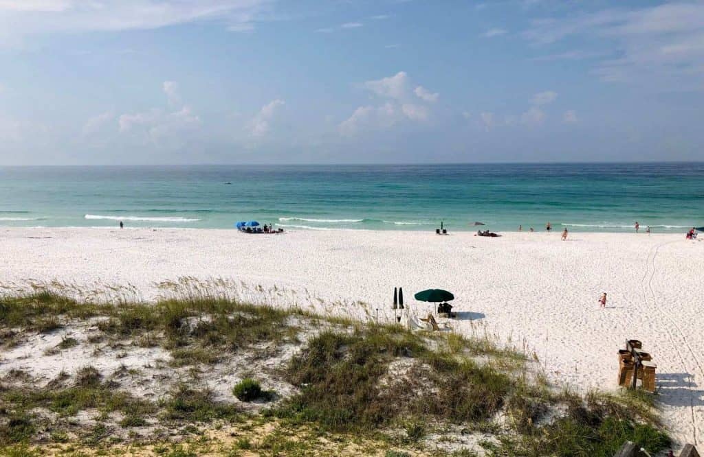 Grass on the sand and the clear emerald waters of Miramar Beach, which is one of the best beaches in the Florida Panhandle.