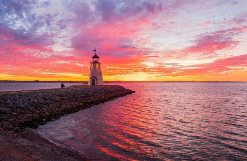 A fiery sunset on Lake Hefner with the lighthouse is another fun things to do during one day in Oklahoma City.