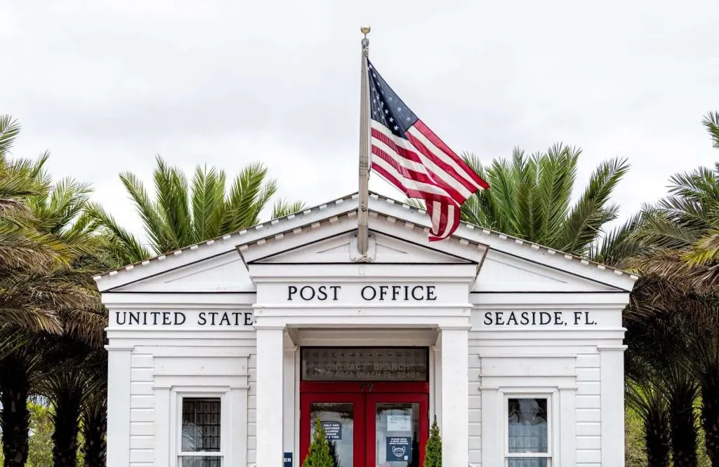 The post office in Seaside Florida with a flag in front of it.