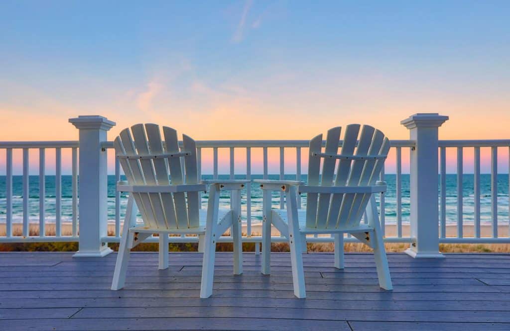 Two chairs on a balcony overlooking the sunset which is one of many things to do in Seaside Florida.