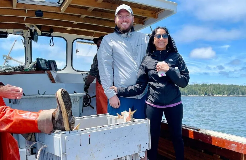 A man and woman on a lobster boat.