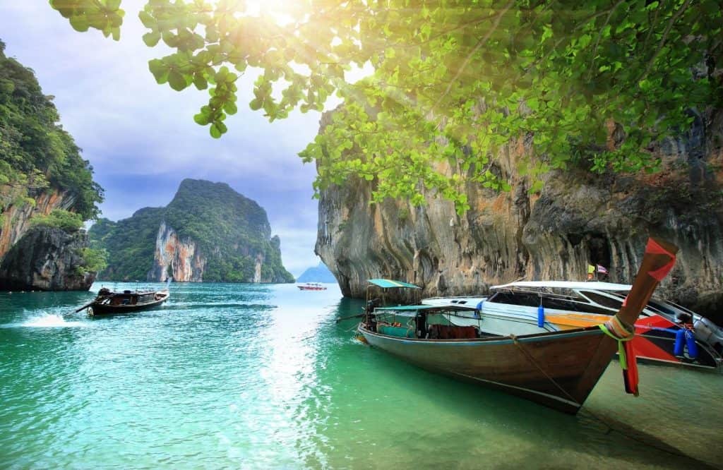Traditional Thai longtail boat and limestone cliffs in Krabi.