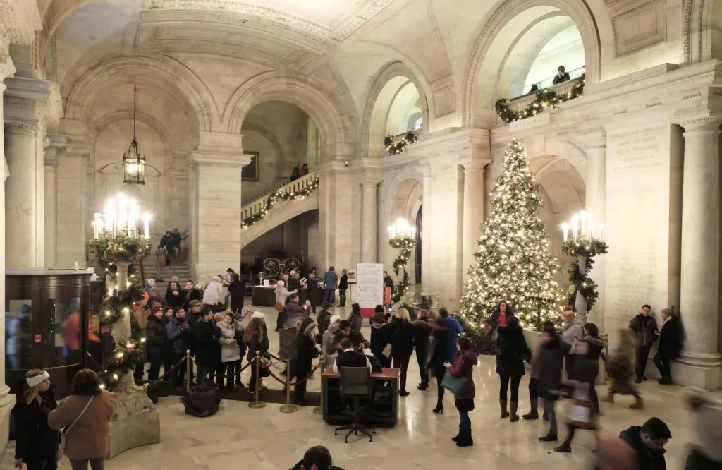 A giant lit up Christmas tree in Astor Hall in New York Public Library.