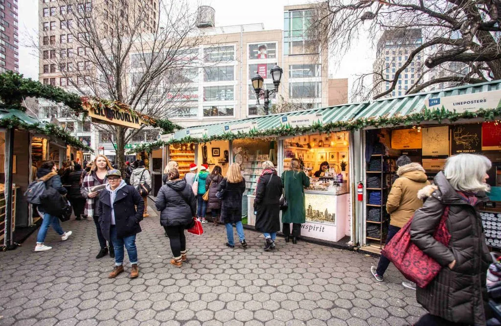 Union Square Holiday Market with people shopping, which is a NYC holiday bucket list item.