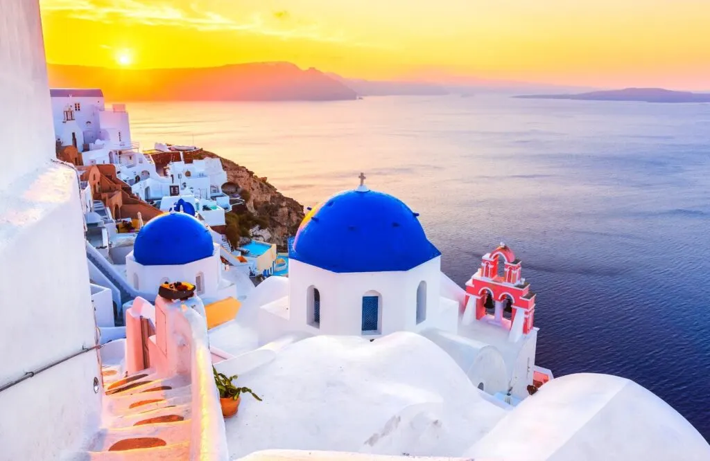 Sunset view of Santorini with the infamous blue domed churches.