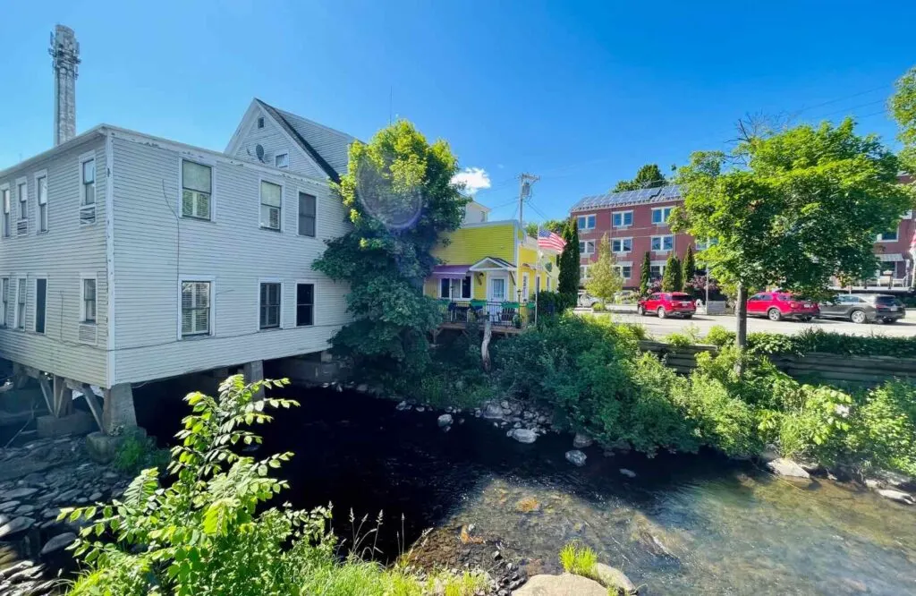 Houses and buildings lined along the Megunticook River in Camden, Maine.