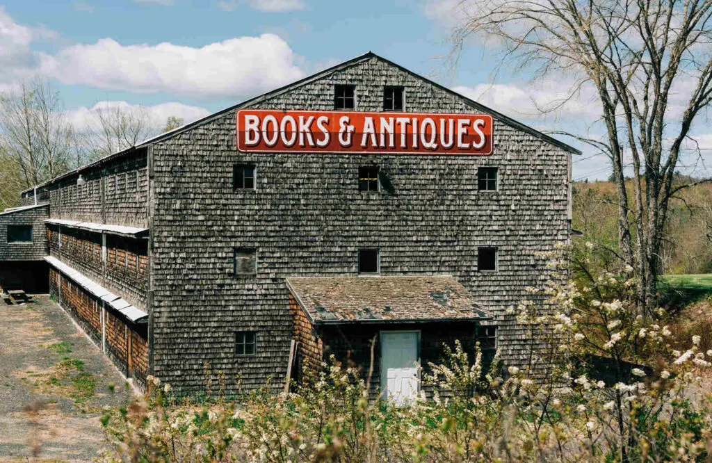 An old barn with a red sign that says "books and antiques" in Ellsworth.