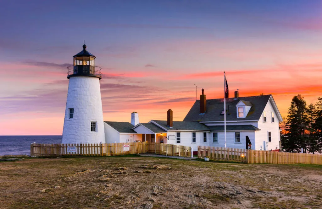Pemaquid Point Lighthouse standing tall under cotton candy colored skies.