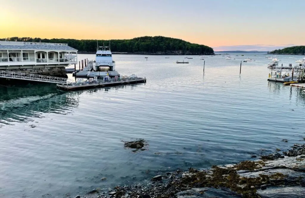 Sunset in Bar Harbor with a boat in the harbor.