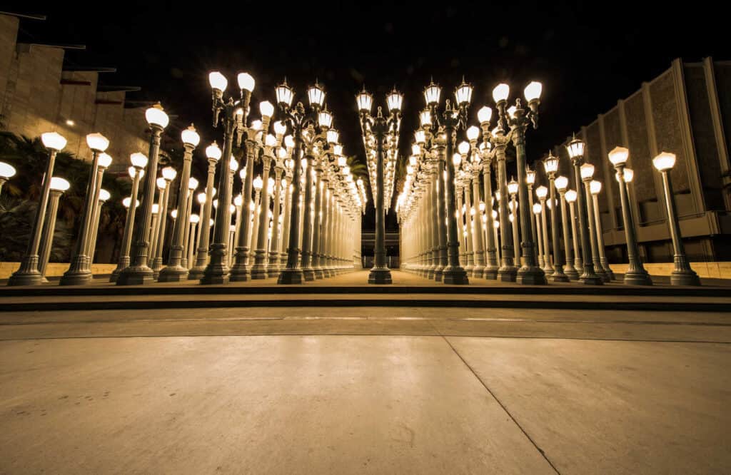 Rows of lit lampposts at night at the Urban Light installation at the Los Angeles County Museum of Art.