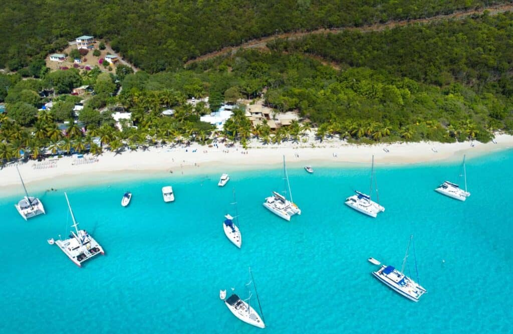 Aerial view of the beach in Jost Van Dyke, British Virgin Islands with boats on the water and trees dotting the shore.