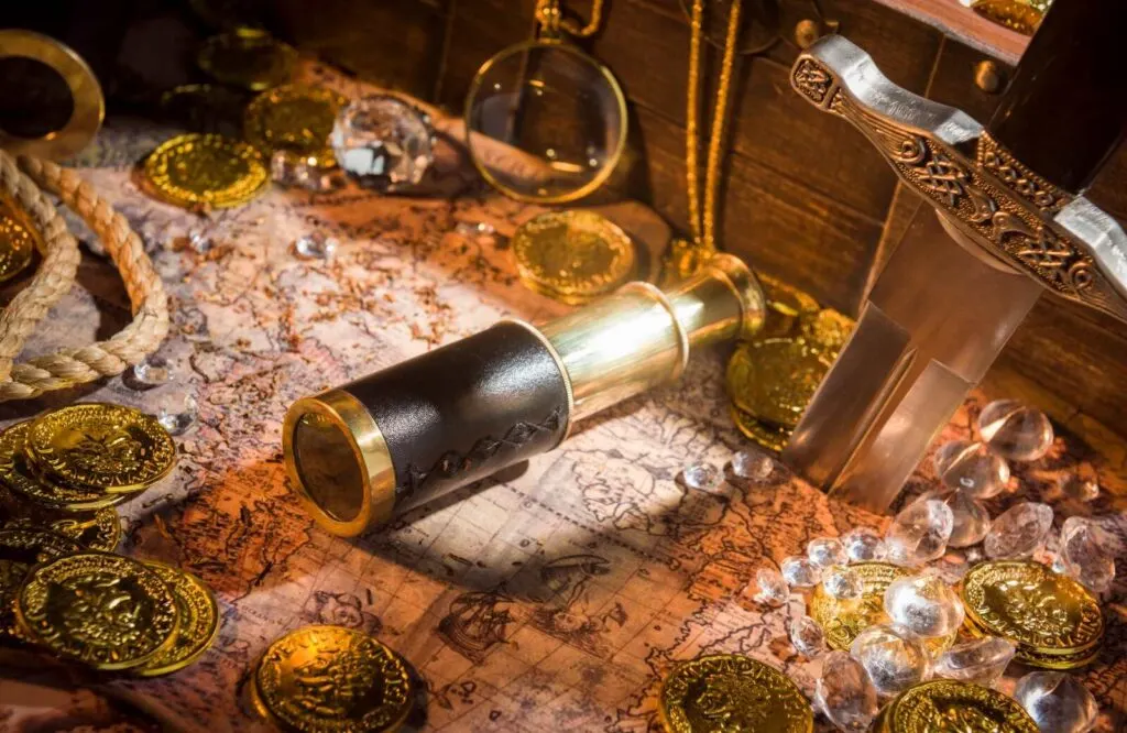 A telescope, coins, and jewels in a pirate's treasure chest.