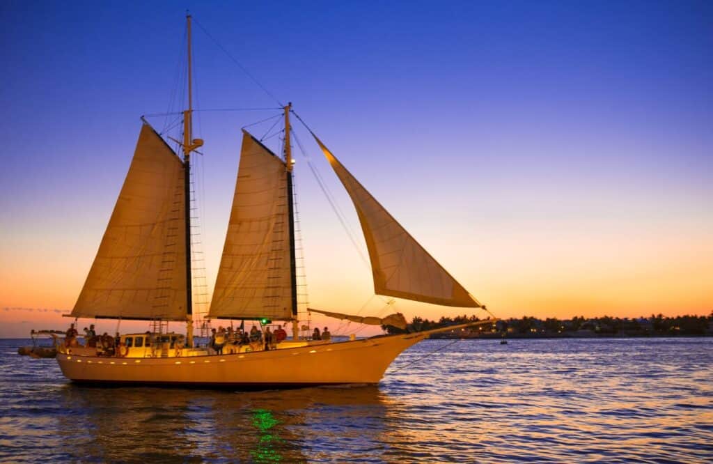 A sailboat with passengers on the water during sunset in Key West.