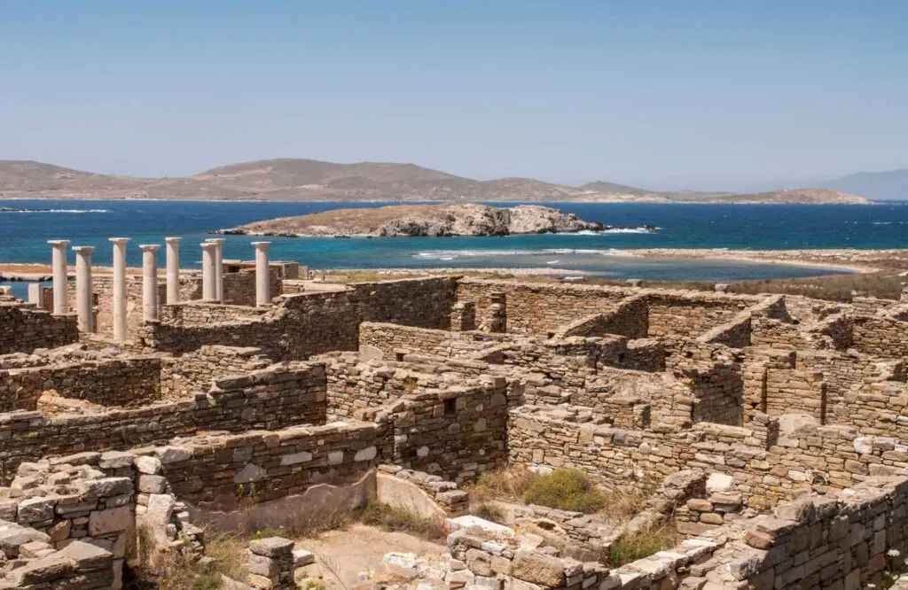 Columns and archaeological ruins in Delos, which is a nearby island to go on a day trip from Mykonos.