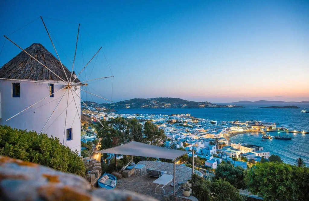 The iconic Mykonos windmills overlooking the town of Mykonos on the ocean.